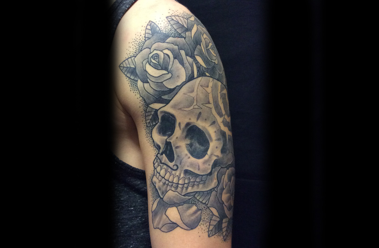 Oberarmtattoo Schädel mit Rosen 